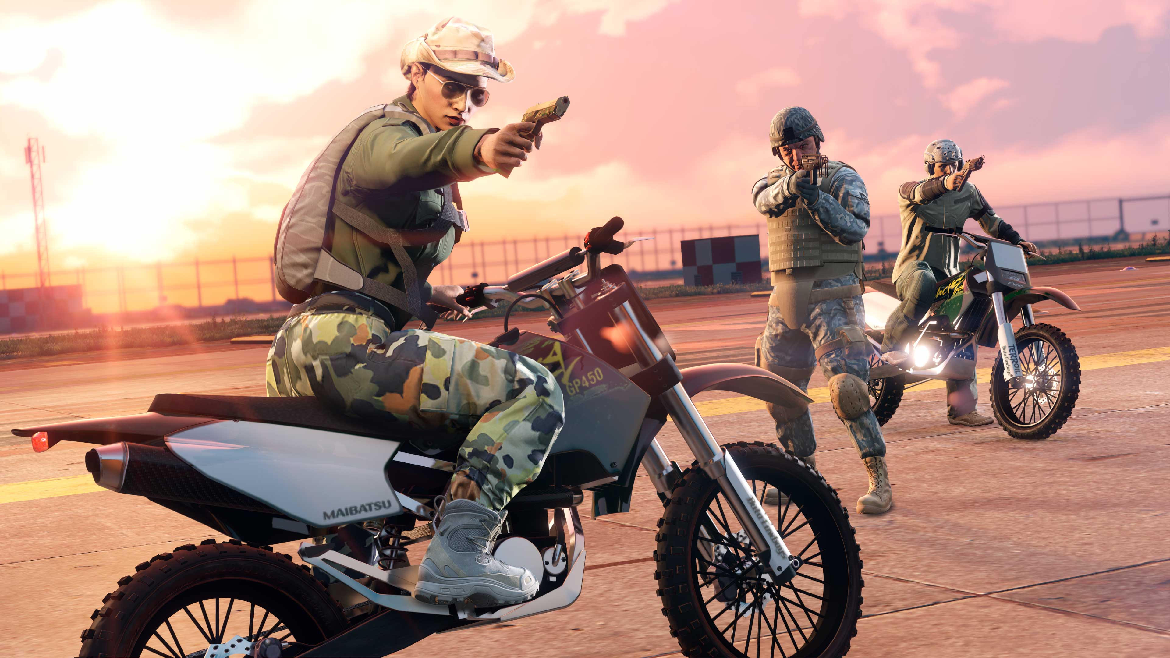 三名身穿军用装备的 GTA 在线模式角色在朝外瞄准武器，两名角色骑着桑切斯越野摩托车。