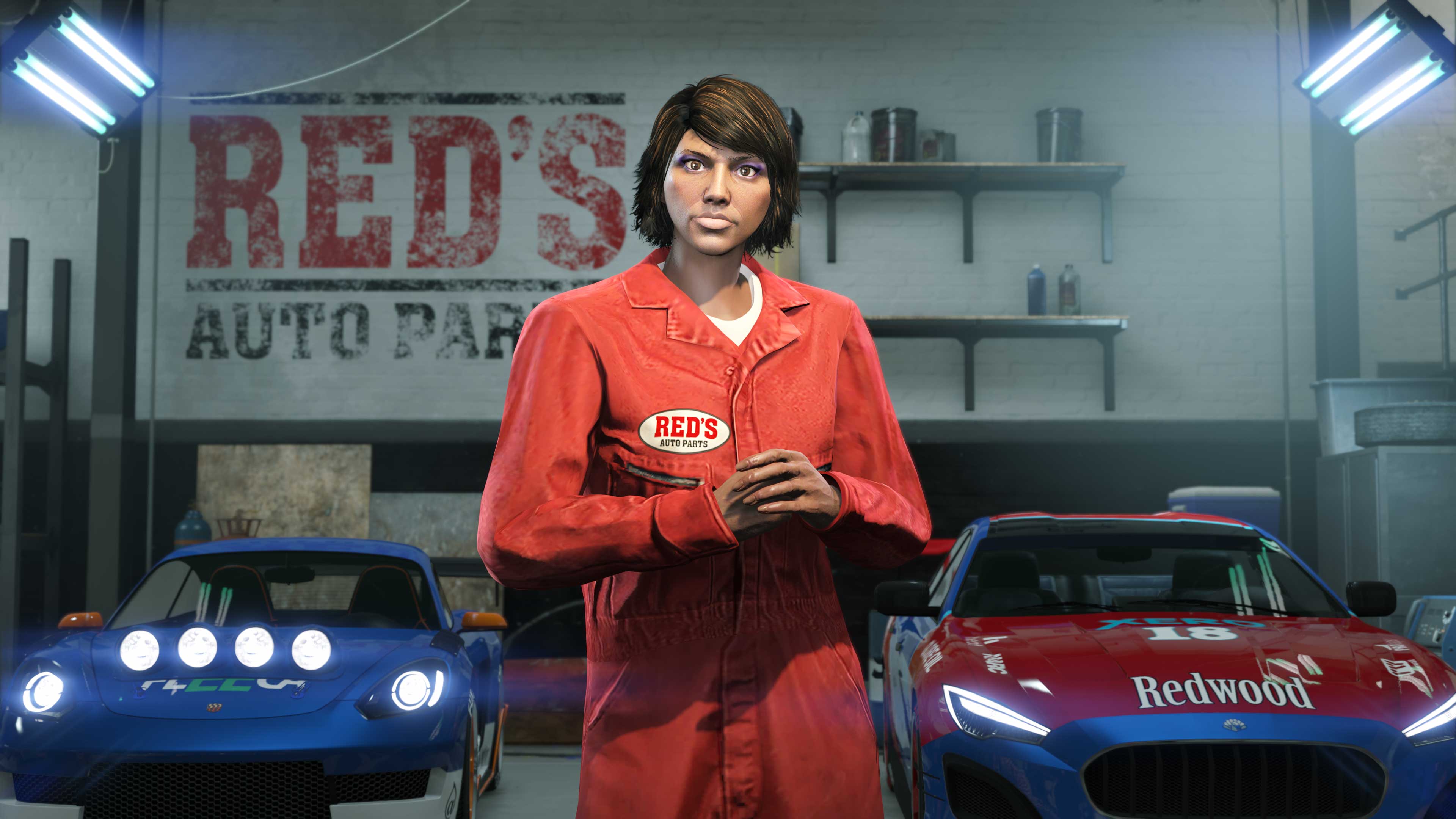 A GTA Online character wears the red “Red’s Overalls” while inside of a garage.